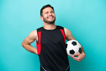 Wall Mural - Young football player Brazilian man isolated on blue background suffering from backache for having made an effort