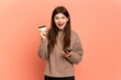 © luismolinero - Young Ukrainian girl isolated on pink background buying with the mobile and holding a credit card with surprised expression