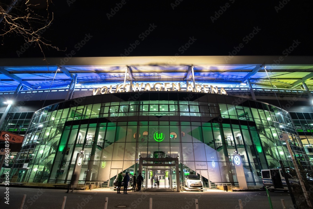 Foto de Stock Illuminated facade (VIP entrance) of Volkswagen Arena stadium after VfL Wolfsburg Bundesliga match. Wolfsburg, Germany - March 2022 | Adobe Stock