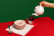 Served breakfast table. Food pop art photography. Tea pot, grapefruit and porridge on red tablecloth over green background. Vintage, retro style interior