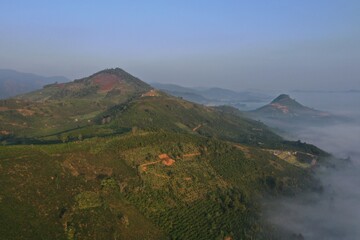 Wall Mural - the fog sea cover valley with an aerial view and green hill ranger at dawn