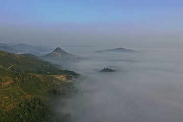 Wall Mural - the fog sea cover valley with an aerial view and green hill ranger at dawn