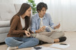 © KMPZZZ - Stressed financial owe asian young couple love sitting suffer, stressed and confused by calculate expense from invoice or bill, no money to pay, mortgage or loan. Debt, bankrupt or bankruptcy people.