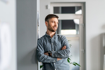 Poster - Successful person. Confident mature businessman standing in modern office hall, posing with crossed hands