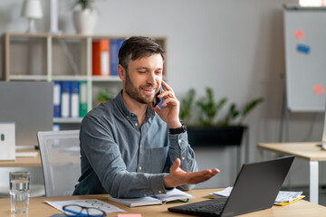 Aufkleber - Happy mature businessman talking on cellphone, discussing work questions, looking at laptop, sitting at workplace