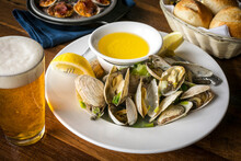 Plated Clam Steamers On A White Plate And Wooden Table