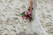 Summer wedding bouquet on a background of sand.