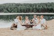 The bride and groom with groomsmen and bridesmaids on the beach.