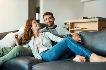 Wall Mural - My weekend has officially kicked off. Full length shot of an affectionate young couple relaxing on their sofa at home.