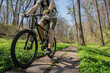 © stenkovlad - Young man on a Bike rides around the track in the forest at sunset