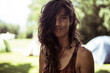 © Cavan Images - natural brown woman smiles in summer camp site in france