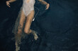© Cavan Images - Overhead view of feminine woman swimming in sparkle dress