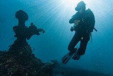 Diver Exploring Underwater Structure In Bali