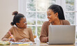 © Kirsten Davis/peopleimages.com - Like mother, like daughter. Shot of a young mother using a laptop while her daughter does homework at home.