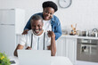 © LIGHTFIELD STUDIOS - happy african american man and woman looking at laptop.