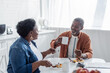 © LIGHTFIELD STUDIOS - smiling african american man talking with senior wife during breakfast.