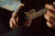 detalle de manos tocando el ukulele. Concepto de musica.