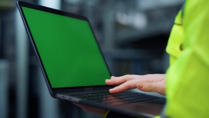 Wall Mural - Greenscreen laptop closeup. Specialist hands typing computer on factory.