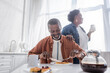 © LIGHTFIELD STUDIOS - senior african american man having breakfast near happy wife.