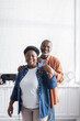 © LIGHTFIELD STUDIOS - happy and senior african american man hugging cheerful wife.