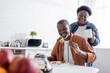 © LIGHTFIELD STUDIOS - senior african american man eating pancakes near happy wife.
