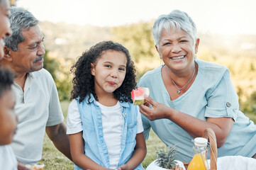 Wall Mural - Family members can be your best friends. Shot of a senior woman feeding her grand daughter some watermelon at a picnic.