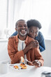 © LIGHTFIELD STUDIOS - joyful and senior african american couple looking at camera during breakfast.