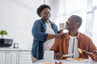 © LIGHTFIELD STUDIOS - senior african american man having breakfast and looking at happy wife.