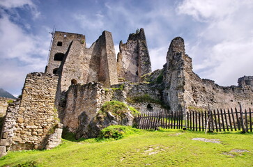 Medieval ruins panorama or castle with beautiful blue sky and green meadow. View of Likava castle ruin in Likavka village in Slovakia.