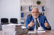 © Elnur - Old male employee and too much work in the office