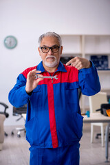 Old male repairman working at workshop