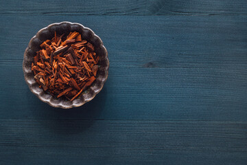 Wall Mural - Ceramic Bowl of Red Sandalwood on Blue Stained Wood