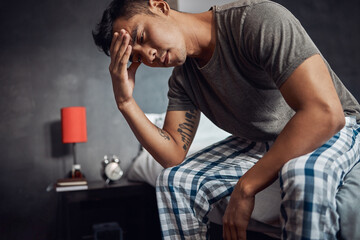 Sticker - Depression hits differently when youre all alone. Shot of a young man feeling unwell in bed at home.