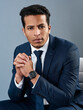 © K Seisa/peopleimages.com - Its just business to him. Studio shot of a corporate businessman posing against a grey background.