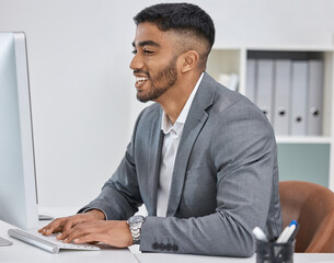 Leinwandbilder - Always working hard to get it all done. Shot of a young businessman working on a computer in an office.