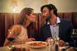 © T Chithambo/peopleimages.com - Nothing inspires romance quite like Italian food. Shot of a young couple sharing spaghetti during a romantic dinner at a restaurant.