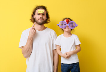 Poster - Funny man and her little daughter with disguise and sticky note on yellow background. April fools' day celebration