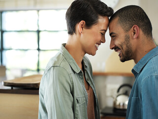 Aufkleber - Sharing one special moment of many. Shot of an affectionate young couple standing playfully face to face in their kitchen.