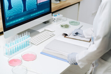 Aufkleber - Workplace of biotechnologist with flasks with blue liquid, petri dishes containing pink substance and computer with covid macro image