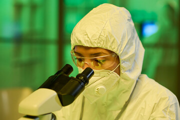 Aufkleber - Contemporary female virologist in protective coveralls using microscope during scientific research or experiment in laboratory