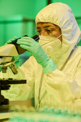 Aufkleber - Young contemporary lab worker in protective coveralls, gloves and respirator studying characteristics of new strain of coronavirus