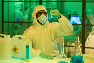 Aufkleber - African American male researcher looking at liquid substance in big test tube during new scientific experiment or clinical trial in laboratory