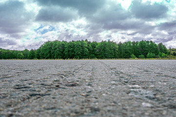 Wall Mural - side view of asphalt country road with dark cloudy sky background