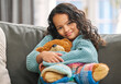 © Kirsten D/peopleimages.com - Comfort in a toy. Shot of an adorable little girl sitting alone on the sofa at home and holding a teddy bear.
