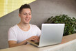 © Dusan - Portrait of a happy young man using laptop.