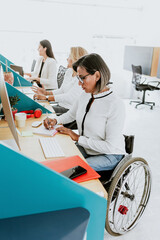 Wall Mural - Latin transgender woman on wheel chair working with computer at the office in Mexico Latin America	