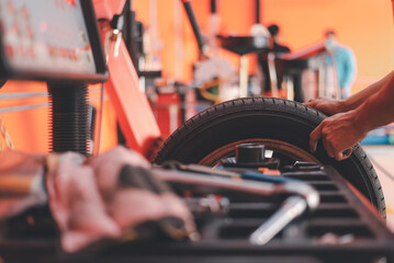 Sticker - Car wheel balancing in tire service., engineer balancing car wheel on balancer in workshop.