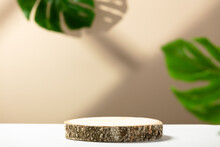 Minimal Modern Product Display On Neutral Beige Background. Wood Slice Podium And Green Tropical Leaves