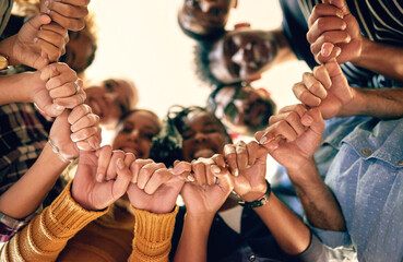 Poster - Nothing can tear our determination apart. Low angle shot of a group of people joining their hands together.