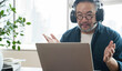 © saksit - Asian middle aged man sitting at home working on video call. Work from home concept